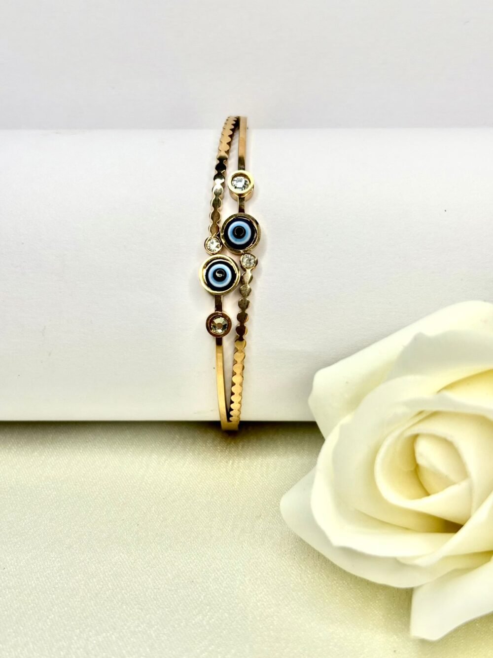 Golden coloured bracelet with two blue evil eye charms